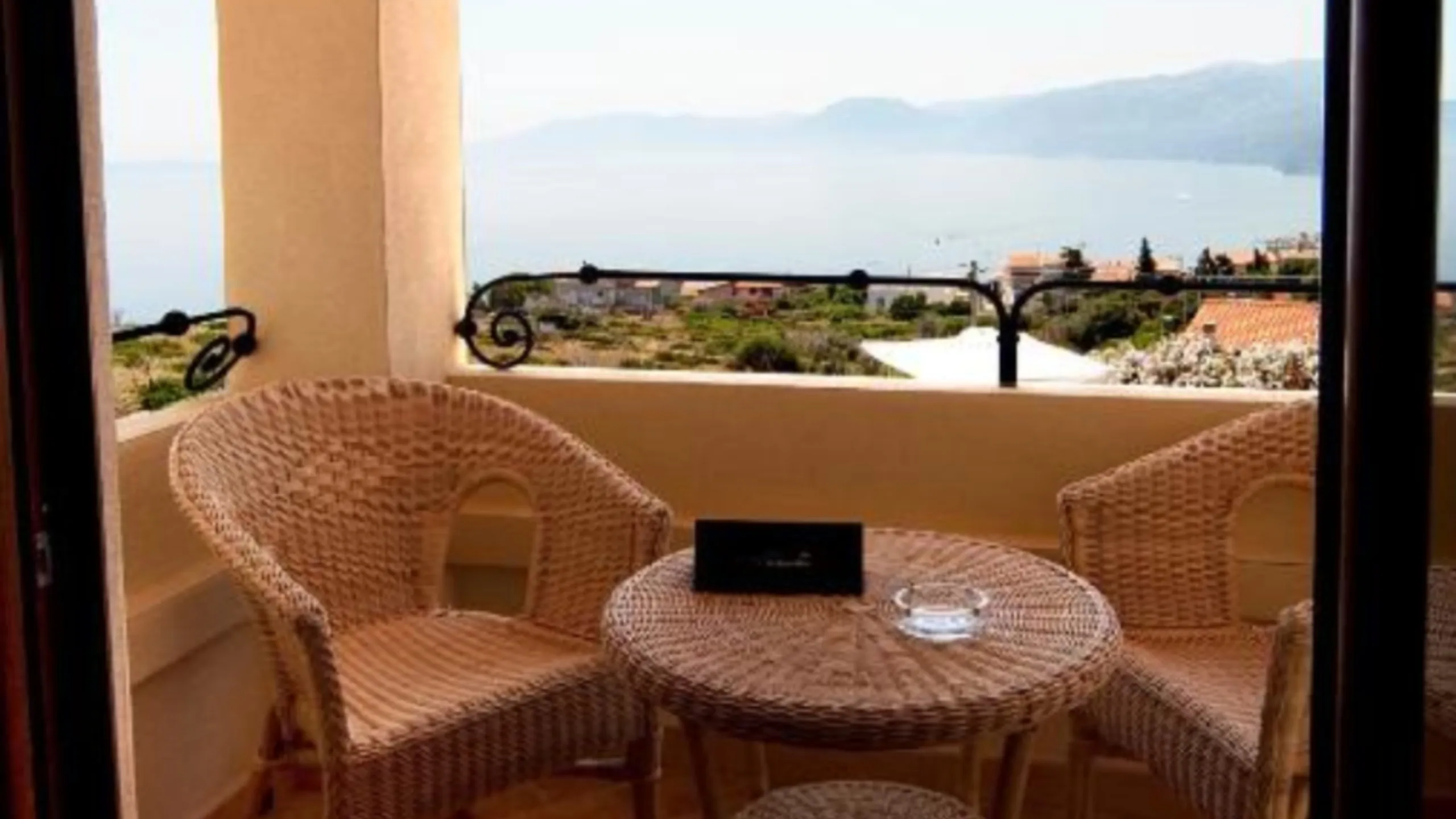 Salotto in vimini sul balcone privato della Suite dell'Hotel Villa Gustui Maris con vista sul Golfo di Orosei.