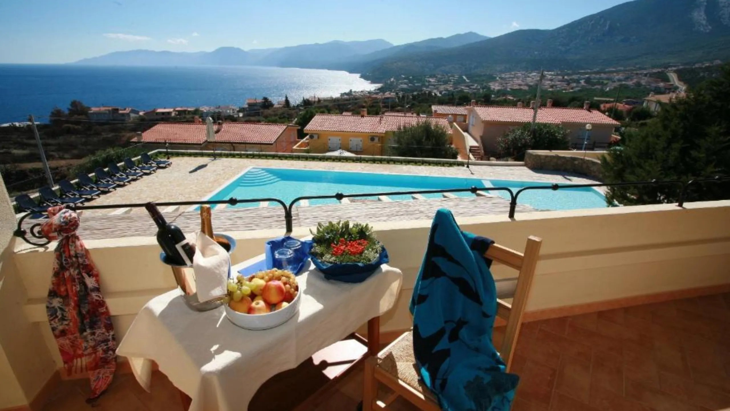 Cesto di frutta e vino sul terrazzo della Suite a Villa Gustui Maris con vista sulla piscina e sul mare.