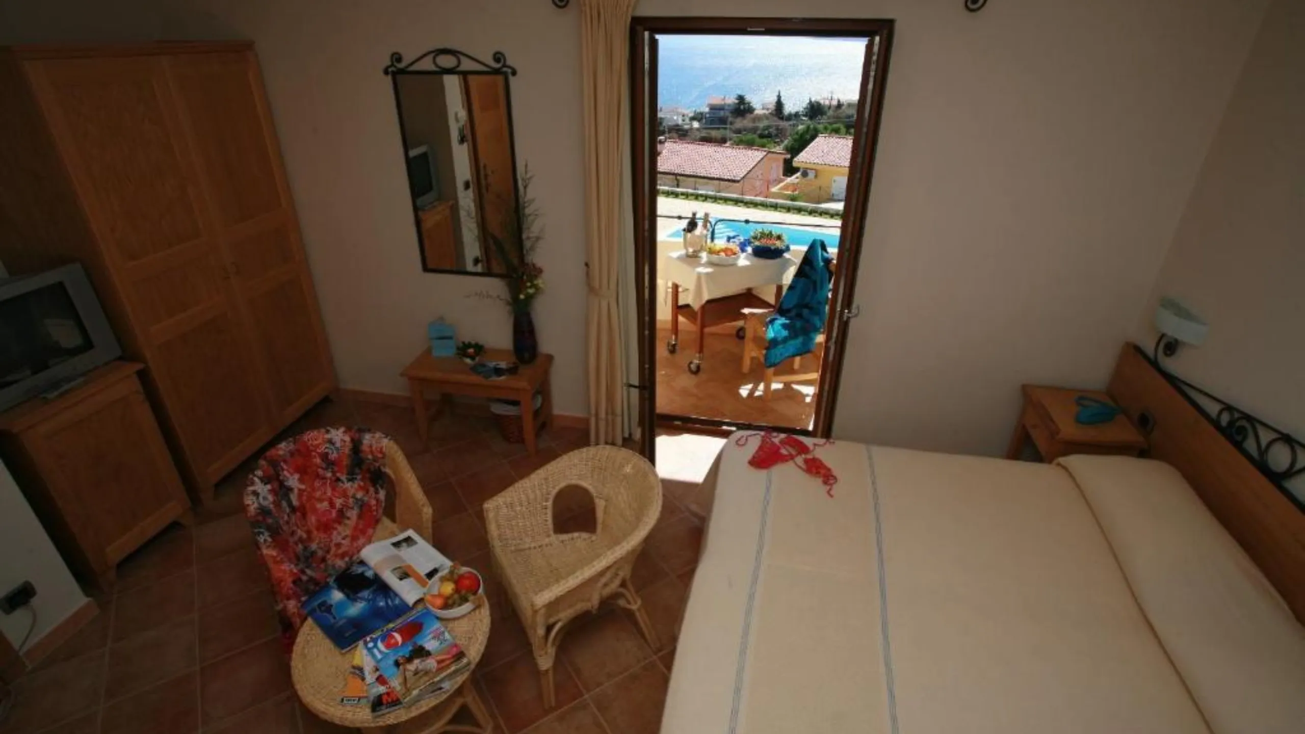 Vista dall'alto della Suite dell'Hotel Villa Gustui Maris con salottino e terrazza affacciata sulla piscina.